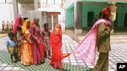 Mina, 8, center, follows her new husband as she visits a temple with Sukhram, 22, right, and his family members. (file)