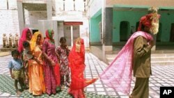 Mina, 8, center, follows her new husband as she visits a temple with Sukhram, 22, right, and his family members. (file)