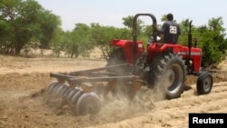 FILE - A farmer plows the field in Saulawa village, on the outskirts of Nigeria's north-central state of Kaduna.