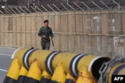 FILE - A South Korean soldier runs along a military fence on the road leading to the truce village of Panmunjom at a South Korean military checkpoint in the border city of Paju near the Demilitarized Zone (DMZ), Nov. 14, 2017.