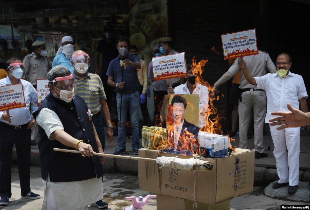 资料照片：2020年6月的中印边境冲突后，在印度新德里举行的一次抗议活动中，印度商人焚烧中国商品和中国国家主席习近平的海报。（2020年6月22日）(photo:VOA)