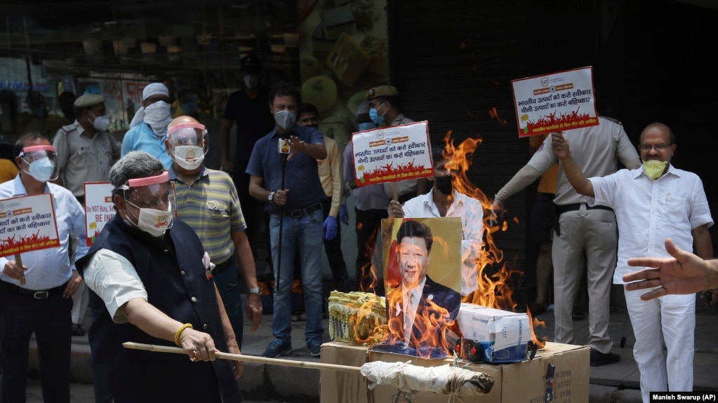 资料照片：2020年6月的中印边境冲突后，在印度新德里举行的一次抗议活动中，印度商人焚烧中国商品和中国国家主席习近平的图像。（2020年6月22日）(photo:VOA)