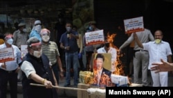 资料照片：2020年6月的中印边境冲突后，在印度新德里举行的一次抗议活动中，印度商人焚烧中国商品和中国国家主席习近平的图像。（2020年6月22日）