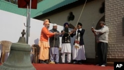 An old bell that was removed is seen in foreground as people from various faiths including Muslims, Hindus and Sikhs ring the new bell during its installation at the Holy Family Catholic Church in Srinagar, Indian controlled Kashmir, Oct. 29, 2017.