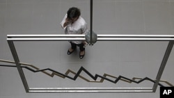 An employee of the Athens Stock Exchange speaks on her cell phone in Athens, August 8, 2011.