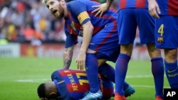Lionel Messi s’inclinant pour assister Neymar du FC Barcelone, touché par un projectile jeté par un spectateur, Valencia, Espagne, 22 octobre 2016.