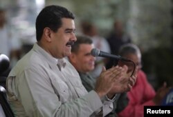FILE - Venezuela's President Nicolas Maduro attends an event with workers in Caracas, Nov. 14, 2017.