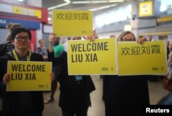 People hold welcome signs as they wait for Liu Xia, widow of Chinese Nobel Peace Prize-winning political dissident Liu Xiaobo, at Tegel airport in Berlin, Germany, July 10, 2018.