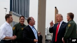 FILE - President Donald Trump reviews border wall prototypes, March 13, 2018, in San Diego.