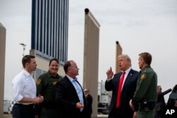 FILE - President Donald Trump reviews border wall prototypes, March 13, 2018, in San Diego.
