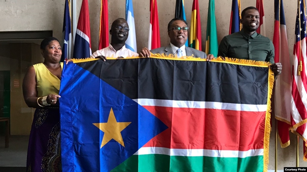 From left, Regina Onyeibe, Africa liaison for Dallas, Dallas-area resident Michael Majok, Dallas City Councilman Dwaine Caraway and pro basketball star Luol Deng participate in the raising of the South Sudanese flag at City Hall in Dallas, Texas, July 2017.