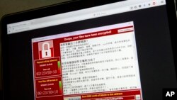 A screenshot of the warning screen from a purported ransomware attack, as captured by a computer user in Taiwan, is seen on laptop in Beijing, May 13, 2017. Dozens of countries were hit with a huge cyberextortion attack Friday that locked up computers and held users' files for ransom at a multitude of hospitals, companies and government agencies.