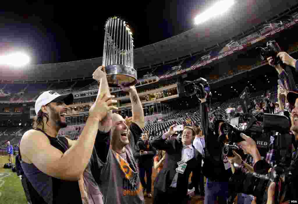 San Francisco Giants left fielder Michael Morse (left) and starting pitcher Tim Hudson hold up the trophy after their 3-2 win in Game 7 of baseball&#39;s World Series against the Kansas City Royals, Kansas City, Missouri, Oct. 29, 2014. 