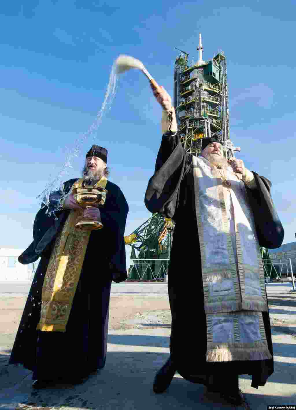 An Orthodox priest blesses members of the media at the Baikonur Cosmodrome launch pad in Kazakhstan. Launch of the Soyuz rocket is scheduled for Dec. 15.