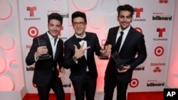 Singers Gianluca Ginoble, left, Piero Barone and Ignazio Boschetto of the group Il Volo, show their awards at the Latin Billboard Awards, April 24, 2014, in Coral Gables, Fla.