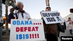 Raul Rodriguez Jr., left, of America First Latinos protests against the Islamic State group ahead of President Barack Obama's visit with the families of shooting victims in San Bernardino, Calif., Dec. 18, 2015. (REUTERS/Patrick T. Fallon)