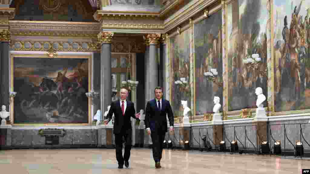 Russian President Vladimir Putin (L) looks around in the Galerie des Batailles (Gallery of Battles) with French President Emmanuel Macron (R) for a joint press conference following their meeting at the Versailles Palace, near Paris.