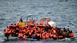 In this photo released by Doctors Without Borders, an overcrowded wooden boat packed with 99 migrants is approached by a tender of the humanitarian organization off the Libya coast on Nov. 16, 2021.