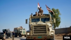 Les troupes irakiennes avancent dans Mossoul portant sur leurs véhicules des bannières chiites en plus du drapeau national irakien, 3 novembre 2016. (VOA/ Jamie Dettmer)