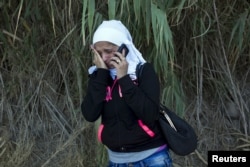 FILE - A Syrian refugee burst into tears while contacting her father in Syria to inform him that she arrived safely on a dinghy on the Greek island of Lesbos, Sept. 11, 2015.