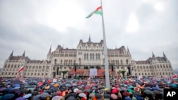 Supporters wait in the rain for Hungarian Prime Minister Viktor Orban's speech outside the Hungarian Parliament building in Budapest, Hungary, March 15, 2018, during celebrations of the Hungarian national holiday.