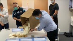 香港民意研究所工作人員7月13日凌晨，打開民主派立法會初選的紙張投票箱進行點票程序。(美國之音湯惠芸)