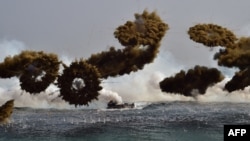 FILE - South Korean Marine amphibious assault vehicles fire smoke shells to land on the seashore during a joint landing operation by US and South Korean Marines in the southeastern port of Pohang on March 30, 2015. South Korean defense officials say the upcoming annual military drill with the United States will be the largest ever.
