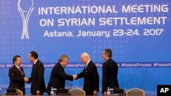 FILE - Participants shake hands after final statement following talks on Syrian peace in Astana, Kazakhstan, Jan. 24, 2017. 