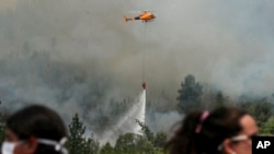 Firefighters drop water on a forest fire in Portezuelo, Chile, Jan. 29, 2017.