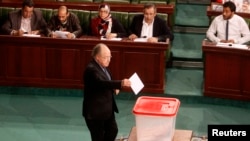 FILE - Tunisia's Speaker of the Assembly Mustapha Ben Jaafar casts his vote over the composition of an election commission that will oversee a vote later this year, Tunis, Jan. 8, 2014.