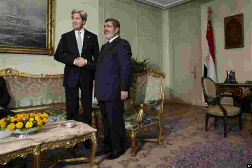 U.S. Secretary of State John Kerry, left, shakes hands with Egyptian President Mohamed Morsi at the Presidential Palace in Cairo, Egypt on Sunday, March 3, 2013. U.S. Secretary of State John Kerry met with Egypt's president Sunday, wrapping up a visit to