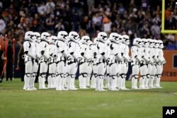 Stormtroopers line up on the field during an NFL football game between the Chicago Bears and the Minnesota Vikings, Oct. 9, 2017, in Chicago. The trailer for "Star Wars: The Last Jedi" debuted during halftime.