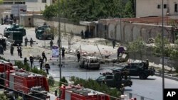 Pasukan keamanan Afghanistan dan petugas tanggap darurat berkumpul di depan kompleks parlemen yang diserang Taliban di Kabul (22/6). (AP/Rahmat Gul)