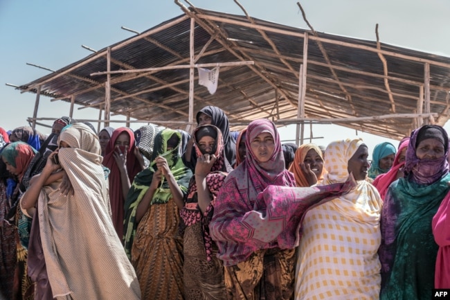 FILE - People gather to receive food at a distribution site in Farbudo, a camp for internally displaced people, in Gode, near Kebri Dahar, southeastern Ethiopia, Jan. 27, 2018. Nearly a million people have been displaced in southern Ethiopia due to ethnic violence.