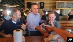 Mitt Romney greets people during a campaign stop at R&R BBQ in South Jordan, Utah, June 26, 2018.