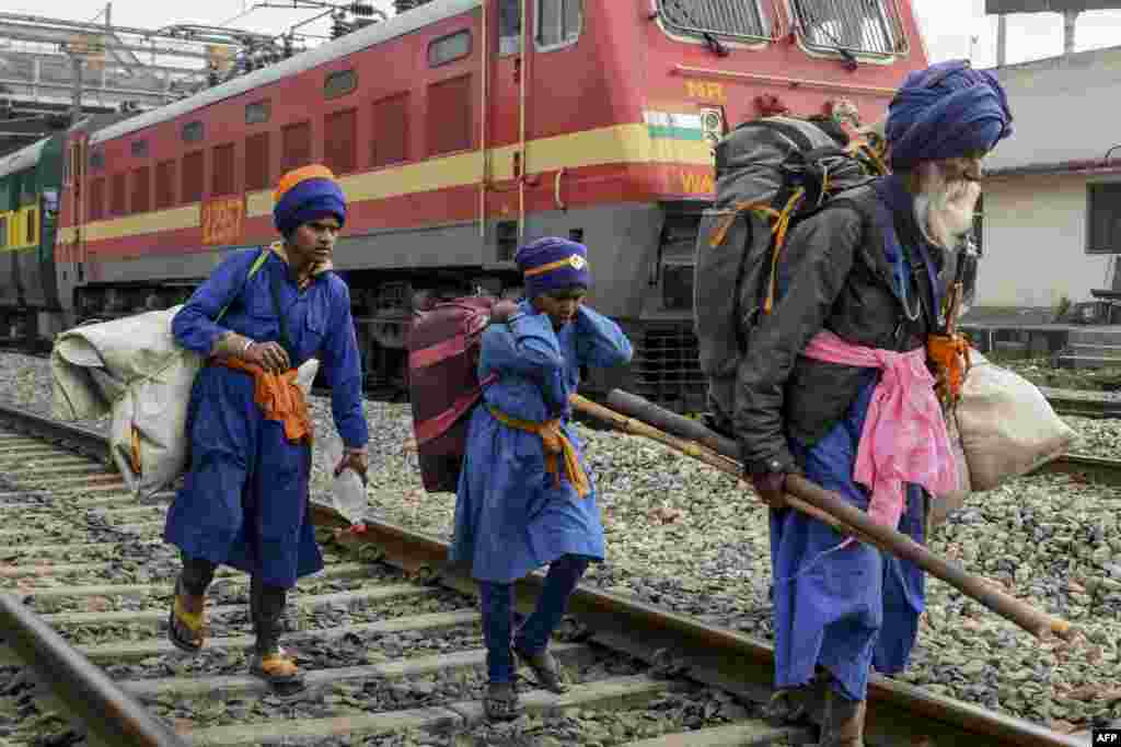 Passengers carry their belongings near the railway station in Amritsar, India, as activists of Communist Party of India Marxist (CPIM) block train tracks during a nationwide general strike called by trade unions aligned with opposition parties to protest the government&#39;s economic policies.