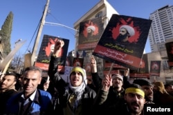 Iranian protesters chant slogans as they hold pictures of Shi'ite cleric Sheikh Nimr al-Nimr during a demonstration against the execution of Nimr in Saudi Arabia, outside the Saudi Arabian Embassy in Tehran Jan. 3, 2016