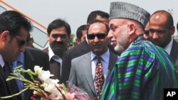 Afghanistan's President Hamid Karzai walks to his vehicle after arriving at a military base in Rawalpindi, Pakistan June 10, 2011.