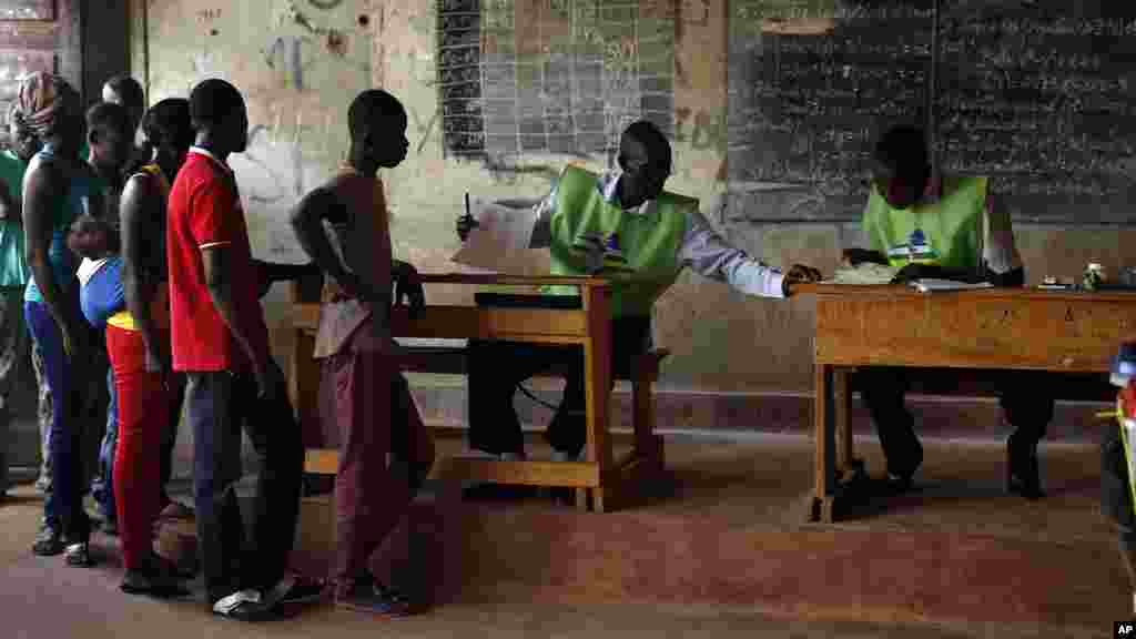 Des électeurs s&rsquo;apprêtent en file à faire leur choix entre deux anciens premiers ministres, Faustin Archange Touadera et Anicet Georges Dologuele, au second tour de la présidentielle à Bangui, en République centrafricaine, 14 février 2016.
