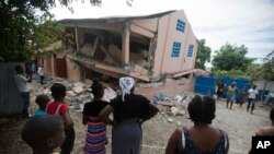 Abanyagihugu bariko baraba inzu yabomotse i Gros Morne, Haiti, itariki 7/10/2018. 
