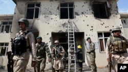 Afghan security personal surround the area after Taliban fighters stormed a government building in Jalalabad, east of Kabul, May 12, 2014. 