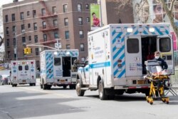 Ambulances line the street outside Elmhurst Hospital Center, Saturday, April 4, 2020 in the Queens borough of New York.