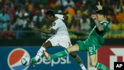 Le Ghanéen Asamoah Gyan, à gauche, marque devant l'Algérien Carl Medjani lors du match de football du Groupe C de la Coupe d'Afrique des nations à Mongomo, Guinée équatoriale, 23 janvier 2015. 