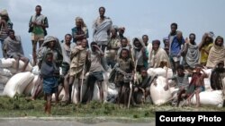 A crowd of stranded villagers gather on the banks of Ethiopia's Lake Tana (the source of the Blue Nile), as sacks of emergency food supplies are unloaded. Weeks of heavy rain have left more than 630 dead and 200,000 homeless and facing the spread of water