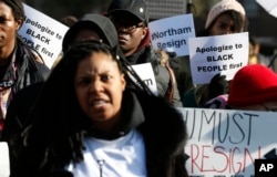 Demonstrators hold signs and chant outside the Governor's Mansion in Richmond, Va., Feb. 2, 2019. The demonstrators were calling for the resignation of Virginia Gov Ralph Northam after a decades-old, racially insensitive photo from his medical school yearbook page was widely distributed Friday.