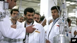 Iranian President Mahmoud Ahmadinejad listens to a technician during his visit of the Natanz Uranium Enrichment Facility, Tuesday, April 8, 2008.