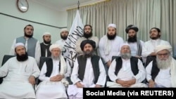 Mullah Baradar Akhund, seorang pejabat senior Taliban, duduk bersama sekelompok pria, membuat pernyataan video, dirilis pada 16 Agustus 2021. (Foto: Media Sosial via REUTERS)