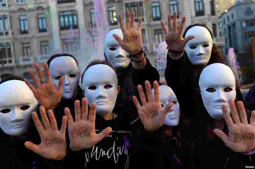 Para mahasiswa jurusan studi gender memakai masker dan menunjukkan telapak tangan mereka yang bertuliskan kata &quot;Cukup&quot; dalam pertunjukan untuk memperingati Hari Internasional untuk Penghapusan Kekerasan Terhadap Perempuan di Oviedo, Spanyol (25/11). (Reuters/Eloy Alonso)