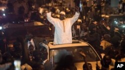 People cheer as President Adama Barrow arrives in Serrekunda, Gambia, Jan. 26, 2017. Barrow returned triumphantly to Gambia, nearly two months after winning an election disputed by the country's longtime dictator, to the cheers of hundreds of thousands who jammed the roads in welcome. 