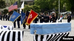 FILE - Members of the United Nations Command honor guards salute in front of boxes containing the remains of the United Nations Command (UNC) and South Korean soldiers who were killed inside North Korea in the 1950-53 Korean War during a repatriation ceremony at Knight Field at Yongsan garrison in Seoul, South Korea, April 28, 2016.